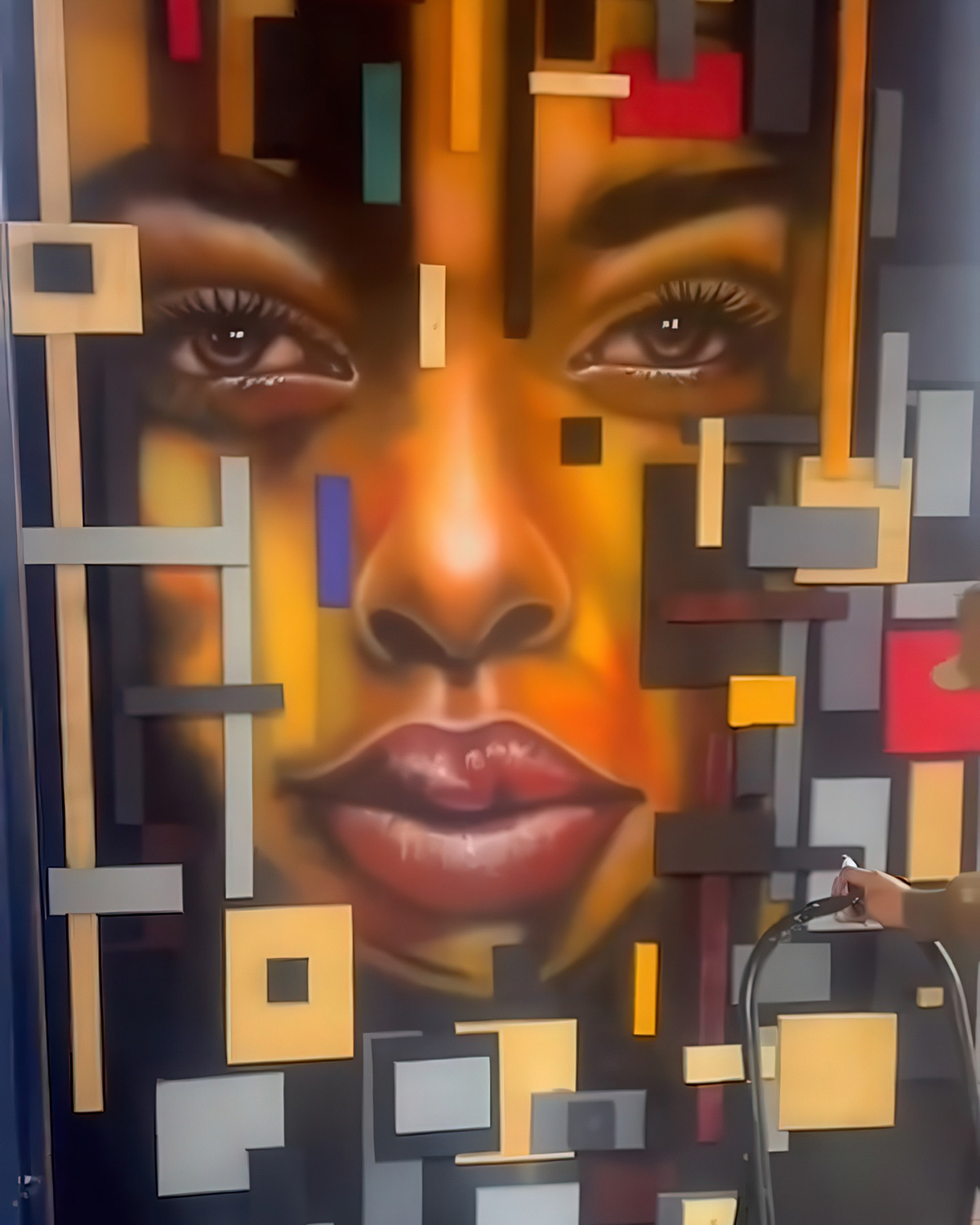 Striking 3D block-relief portrait mural of a woman's face by La Sombra Art Studio